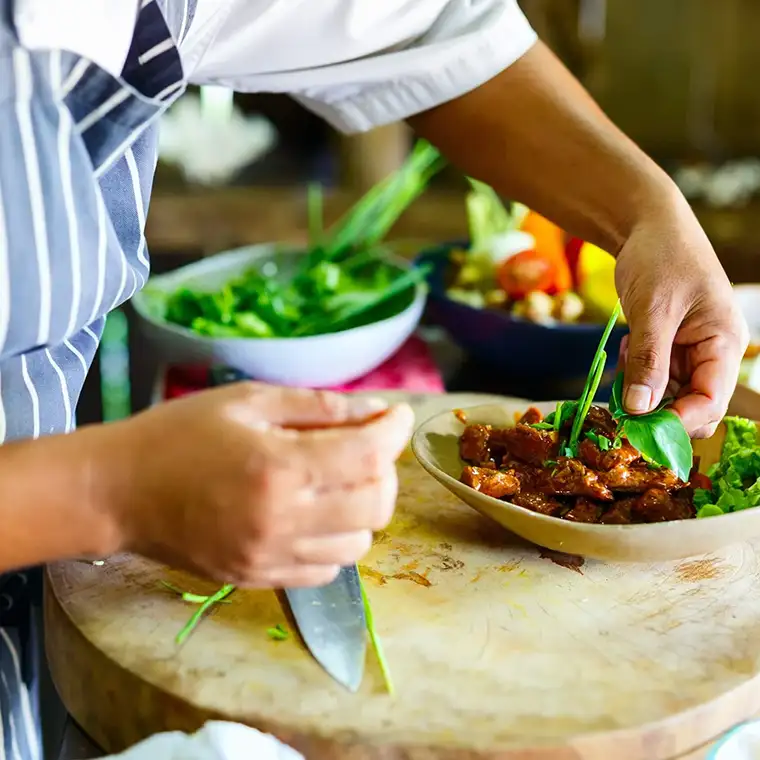 Food Service Assistant (FSA) or Kitchen Hand preparing and plating meals in a healthcare facility