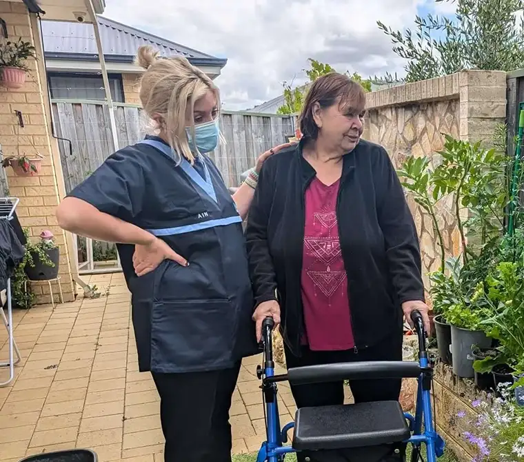 Qualified support staff assisting clients with mobility in community settings across WA