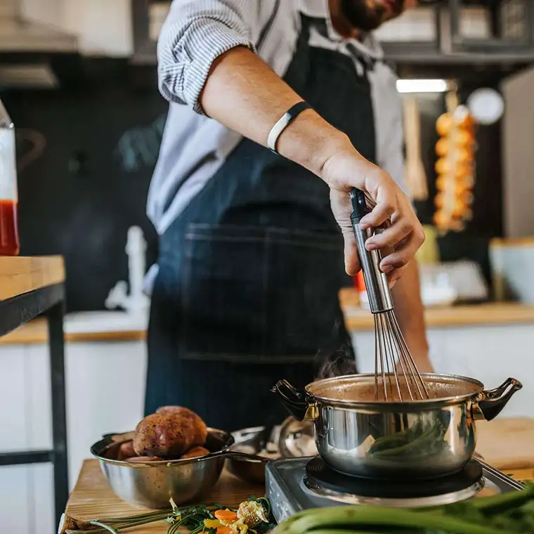 Skilled cook preparing nutritious meals in a healthcare facility kitchen